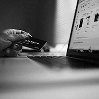 black and white image of an e-commerce website and person holding a credit card