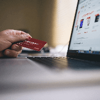 image of an e-commerce website and person holding a credit card
